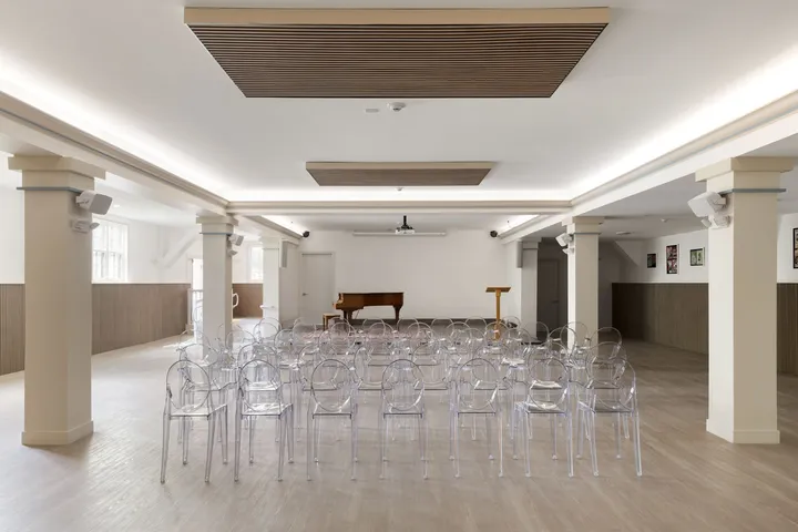 Church Community Space — event hall with piano and ghost chairs